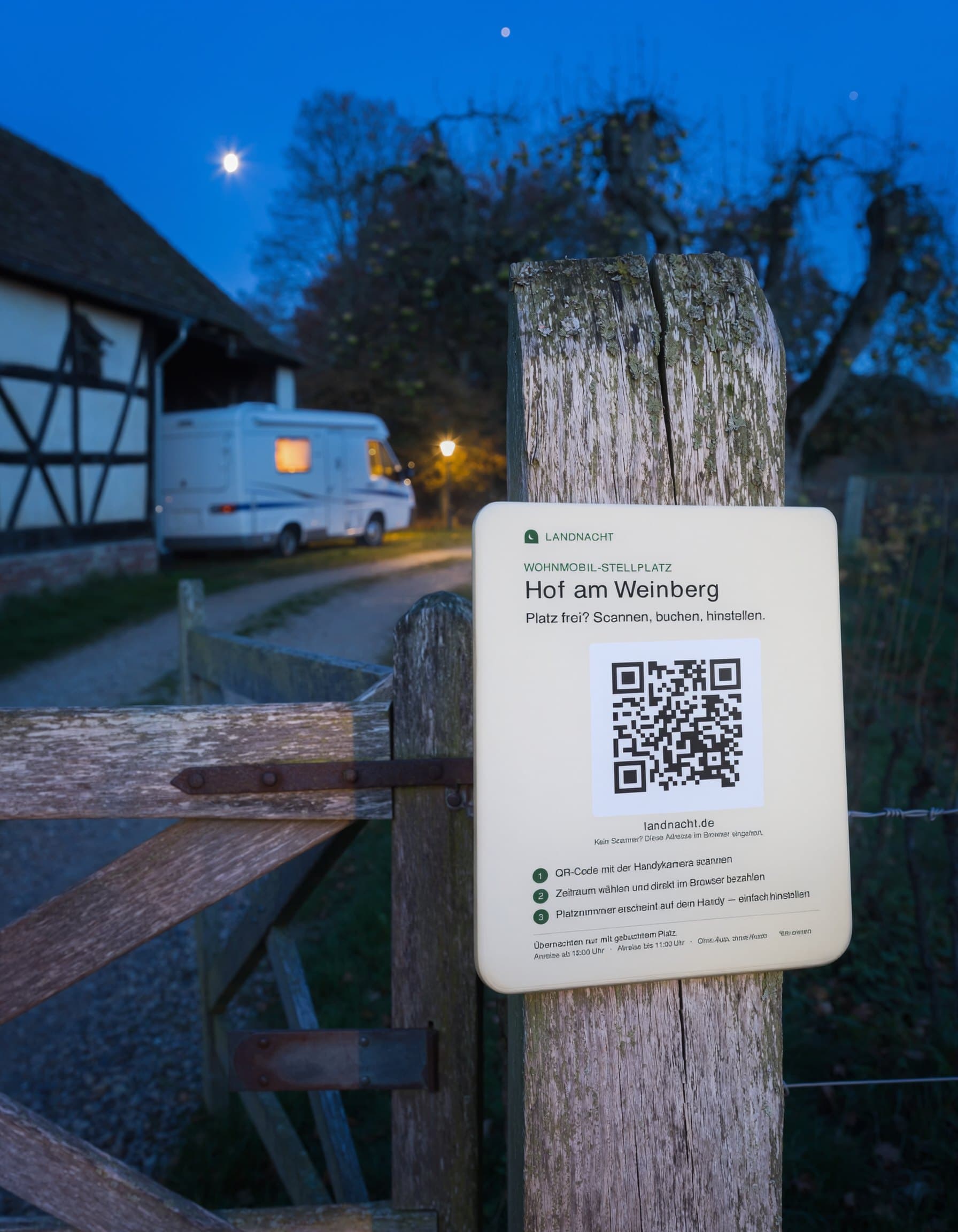 Landnacht-Schild mit QR-Code an einem Holzpfosten am Hoftor, dahinter ein Wohnmobil vor dem Hof in der Abenddämmerung